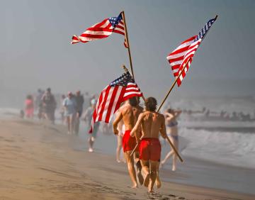 Lifeguards carrying American flags on beach